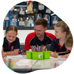 two students and a teacher at a table