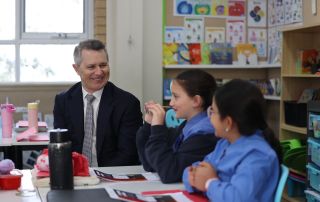 A photo showing Minister for Education Jason Clare interacting with happy students St Luke’s Catholic Primary School Revesby